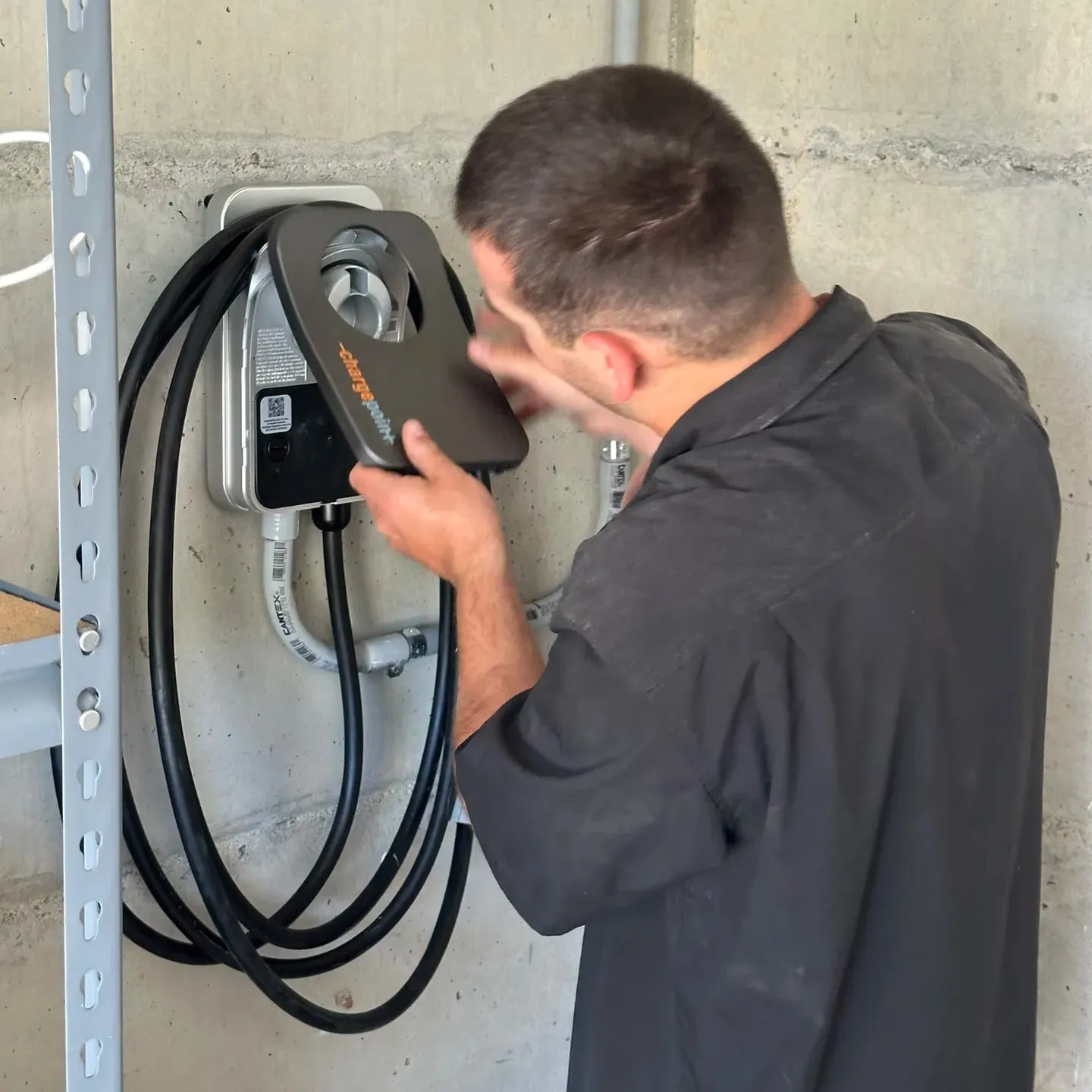 Electrician making the final connections on a ChargePoint EV charger during installation