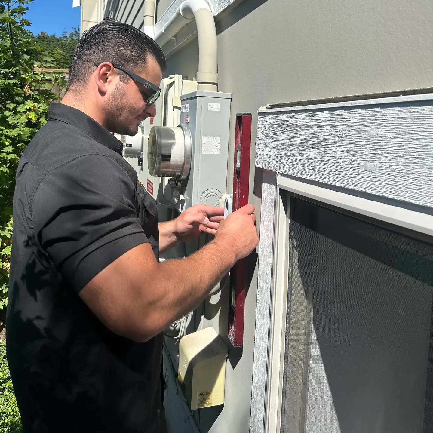 Electrician working at the service entrance on the side of a house