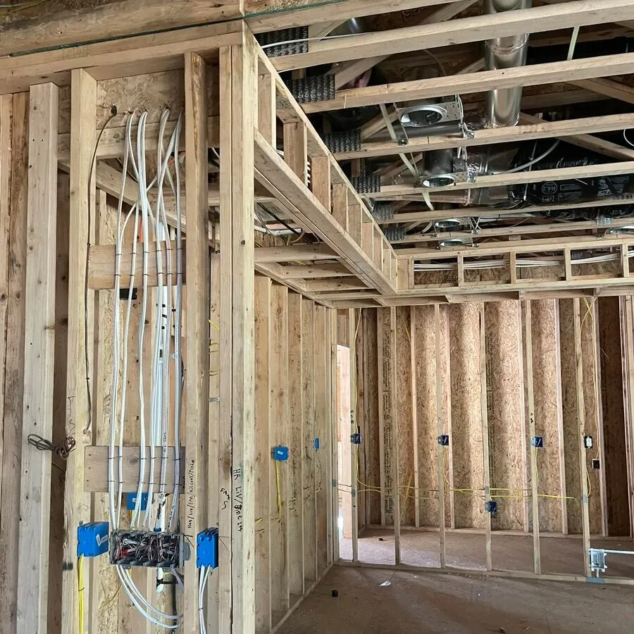 New construction rough-in with branch circuits fanning out through the open studs