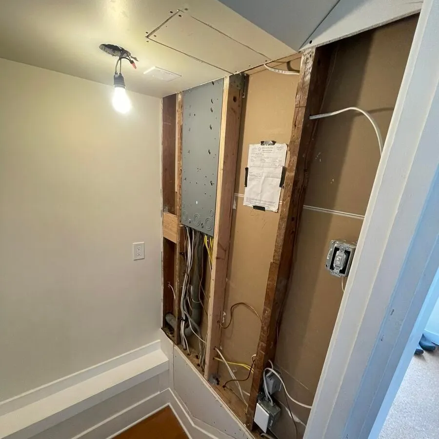 Remodel in progress with the drywall and light fixture removed for access to the panel and its circuits