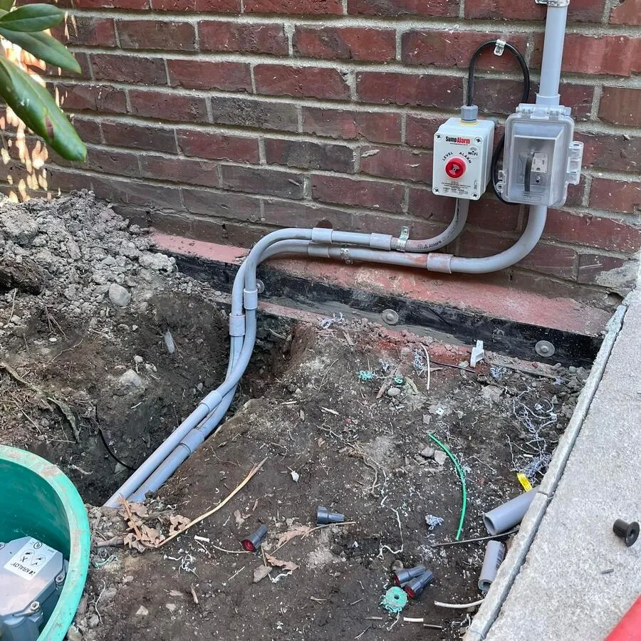 Conduit from the septic controls to the tank, laid in an open trench