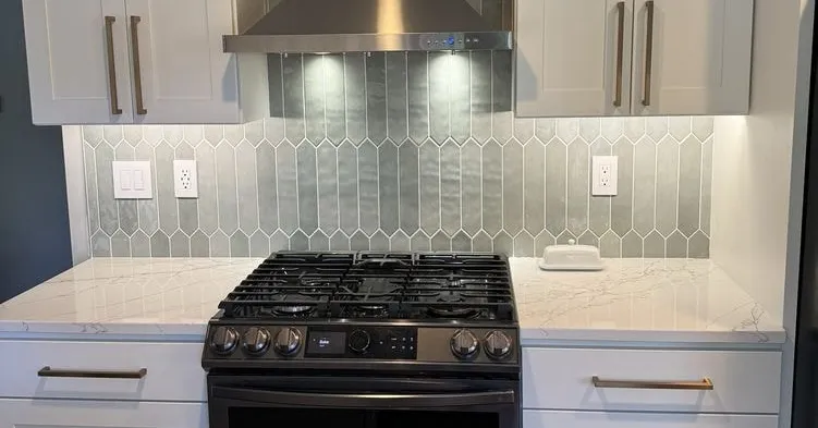 Finished kitchen remodel with under-cabinet lighting, a wall oven, and a fume hood