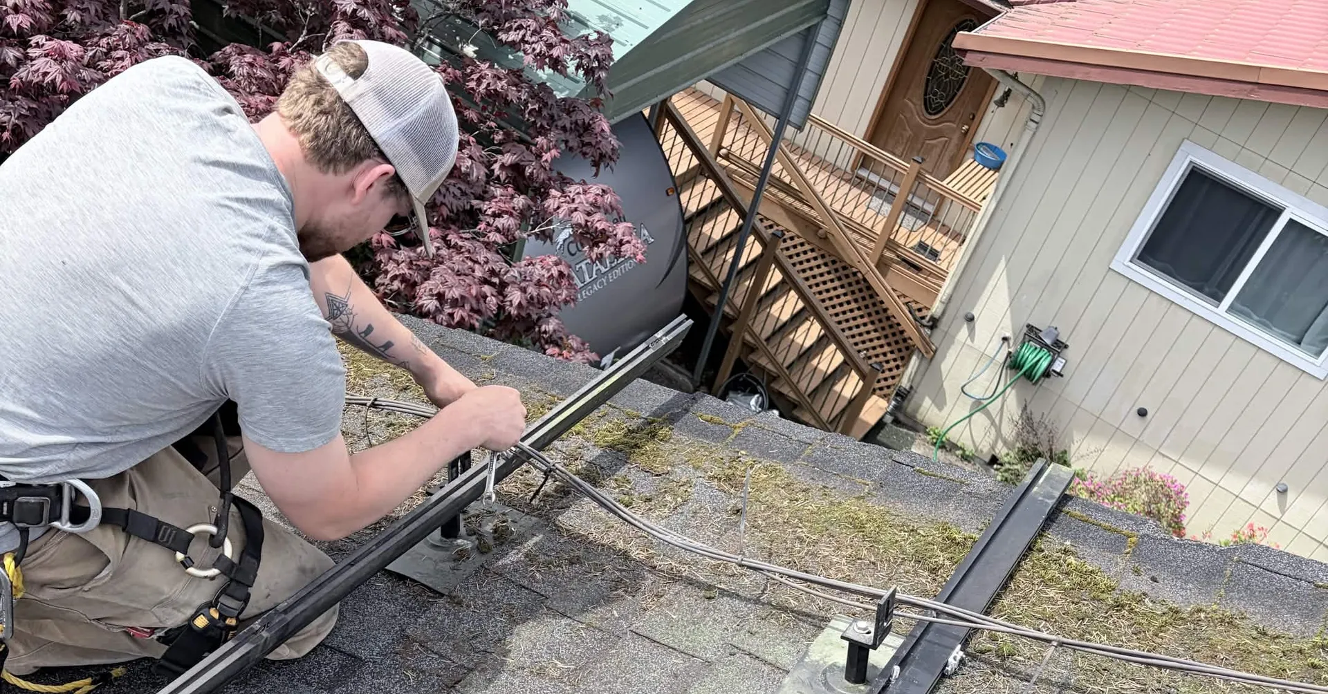 Electrician running wiring along the mounting rails before the solar panels go on