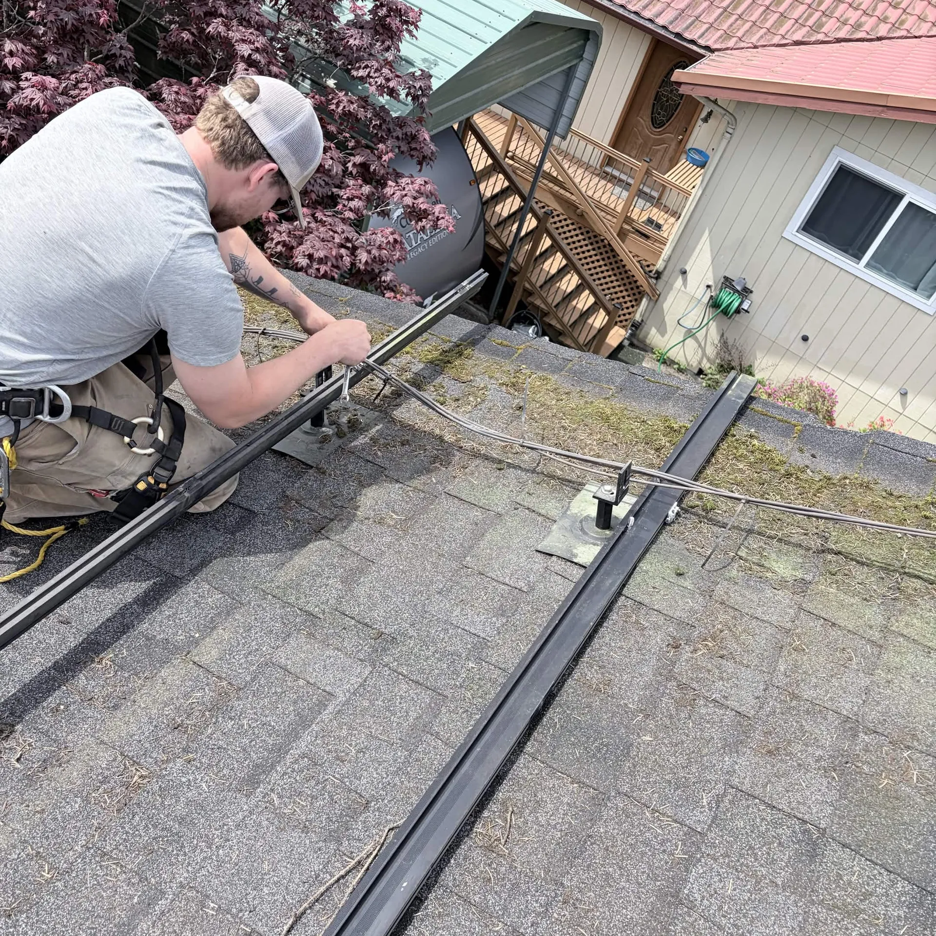 Electrician running wiring along the mounting rails before the solar panels go on