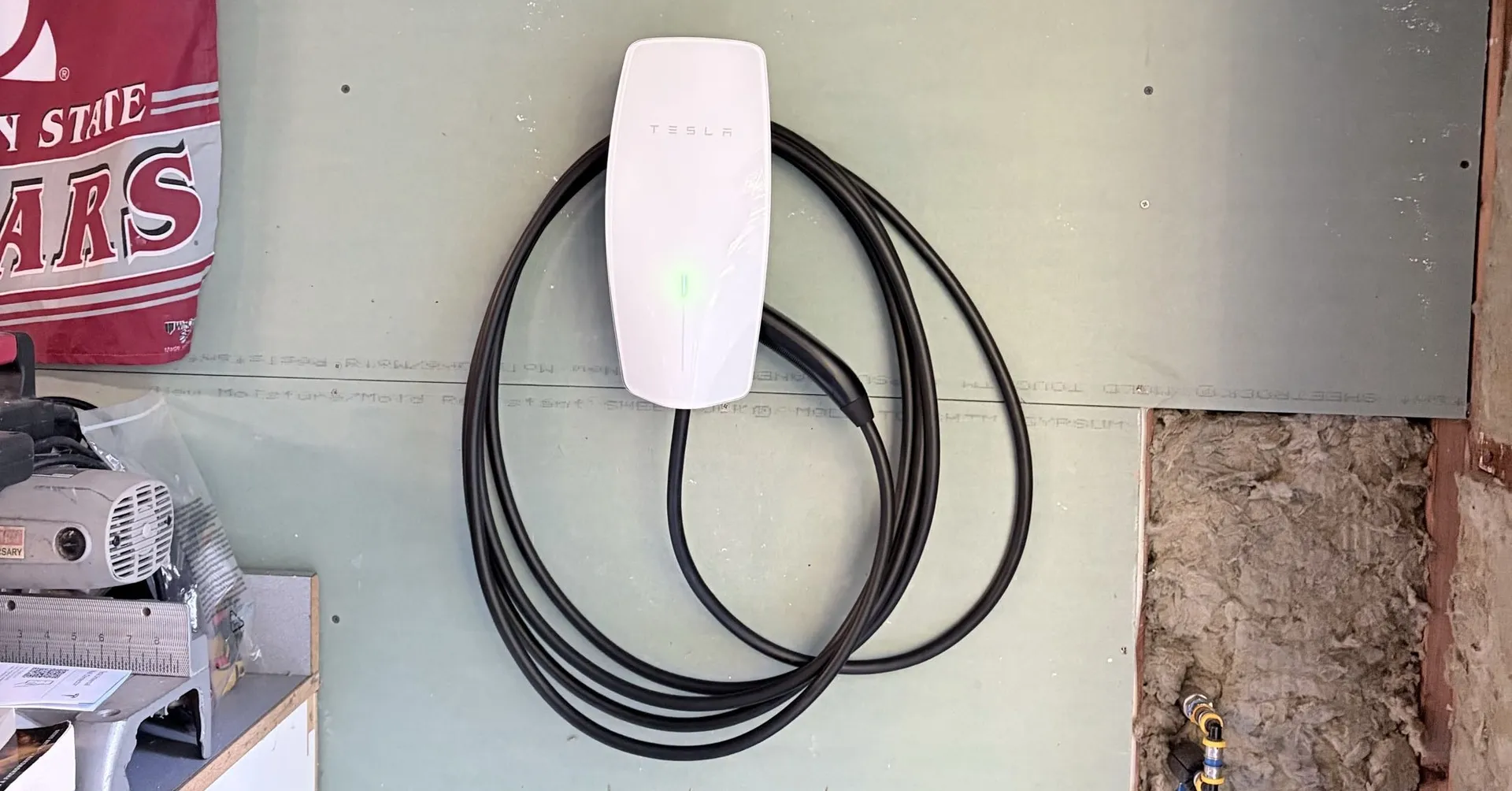 Tesla Wall Connector mounted on a garage wall and ready to charge