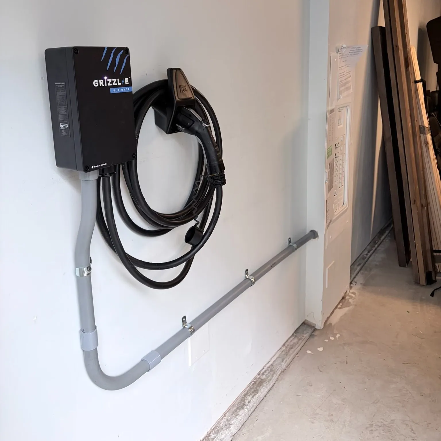 Grizzl-E EV charger installed in a garage a few feet from the panel, fed by an exposed conduit run