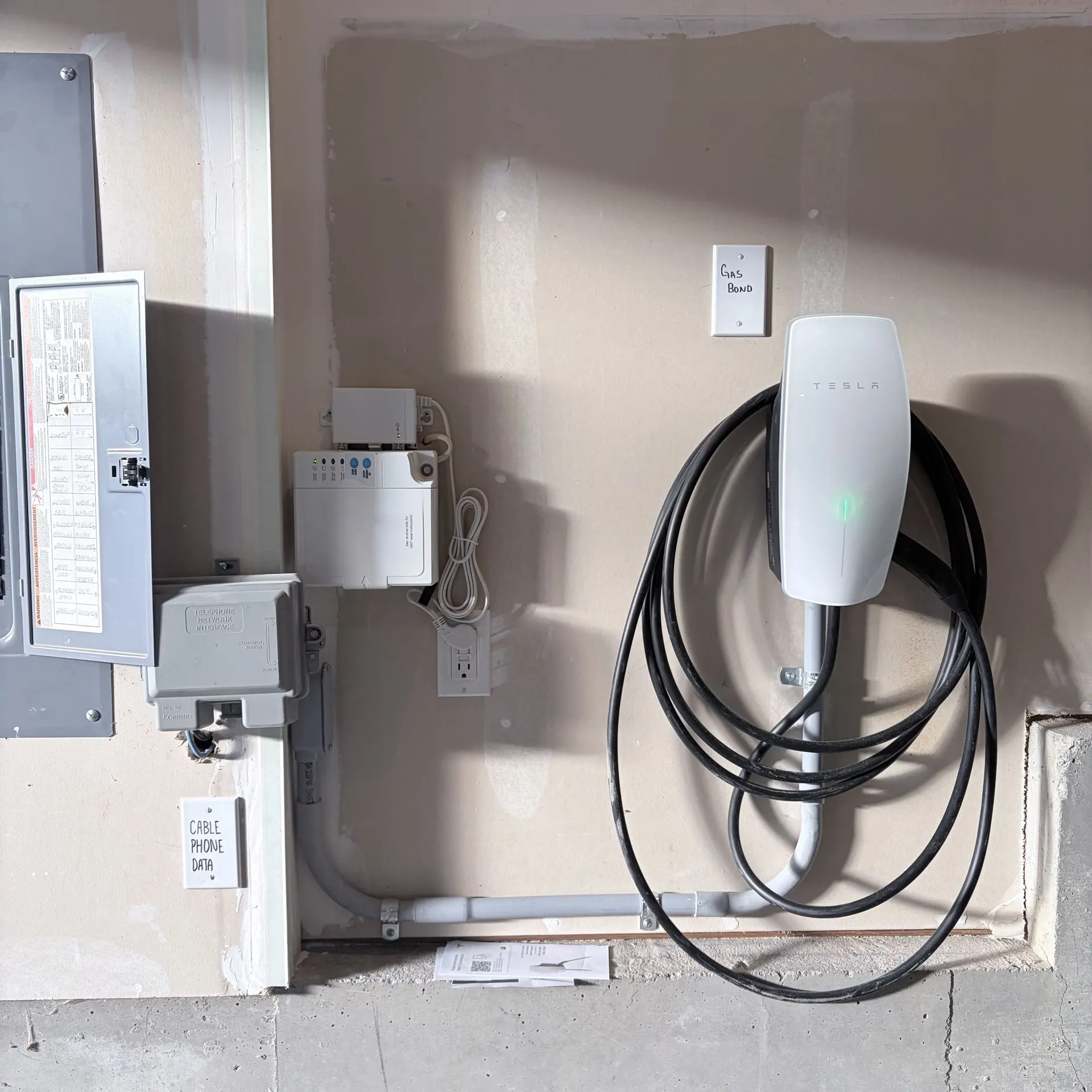 Tesla Wall Connector installed in a garage a couple of feet from the electrical panel